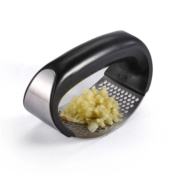 Curved stainless steel rocking garlic press on a kitchen counter